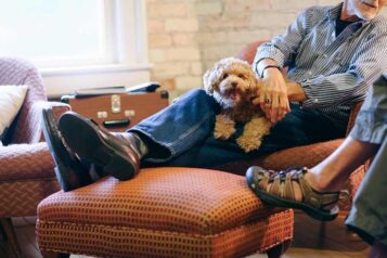 A man sitting on a chair with a dog